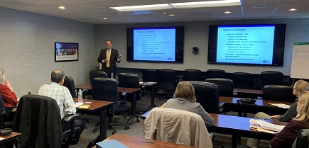 BST employee standing in front of a presentation while leading a seminar 