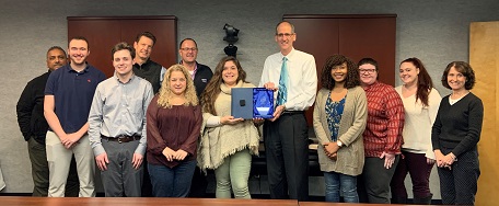 Employees gather for a photo holding a first place award