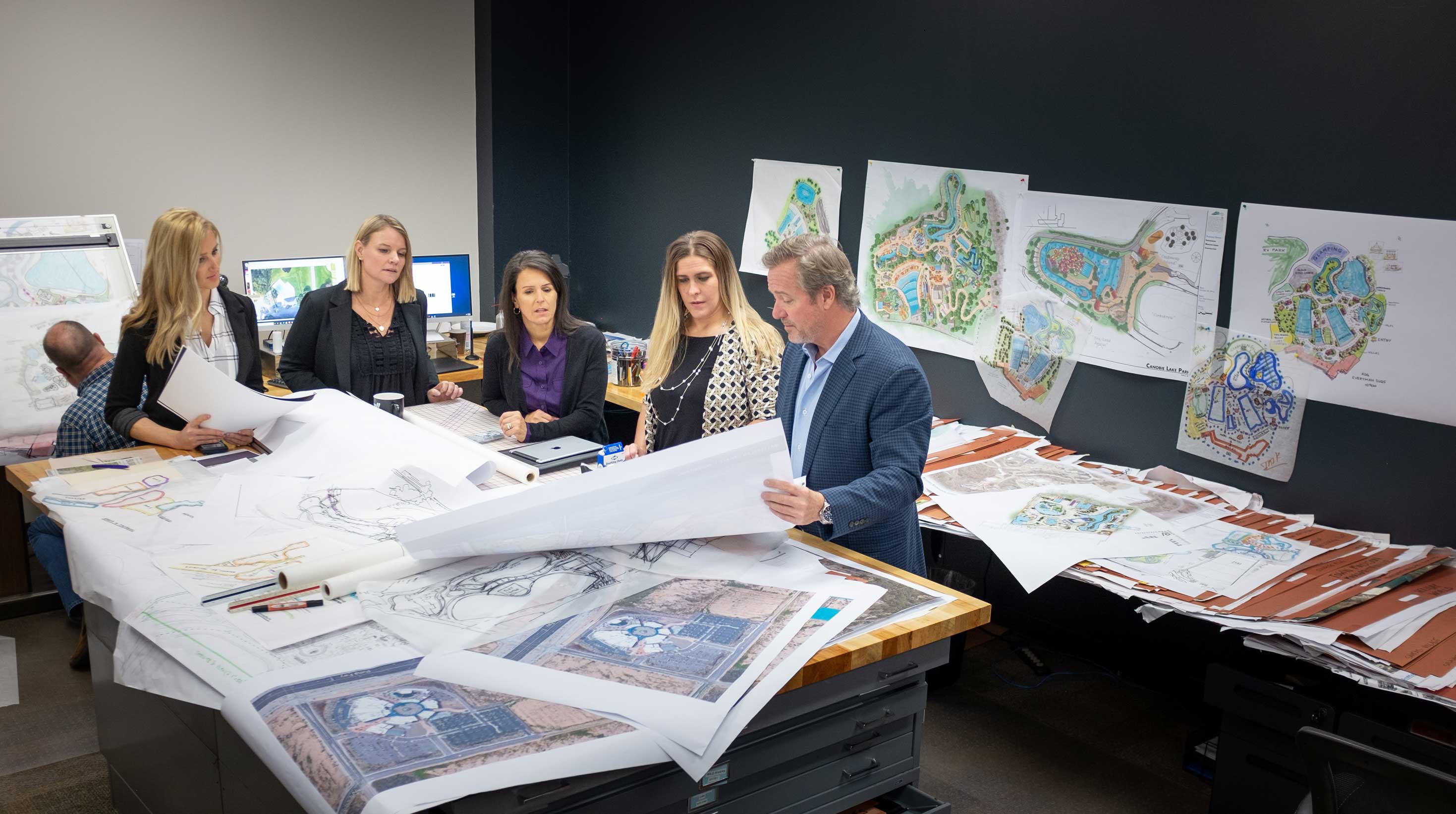 BST Advisors with clients around large blueprints and drawings